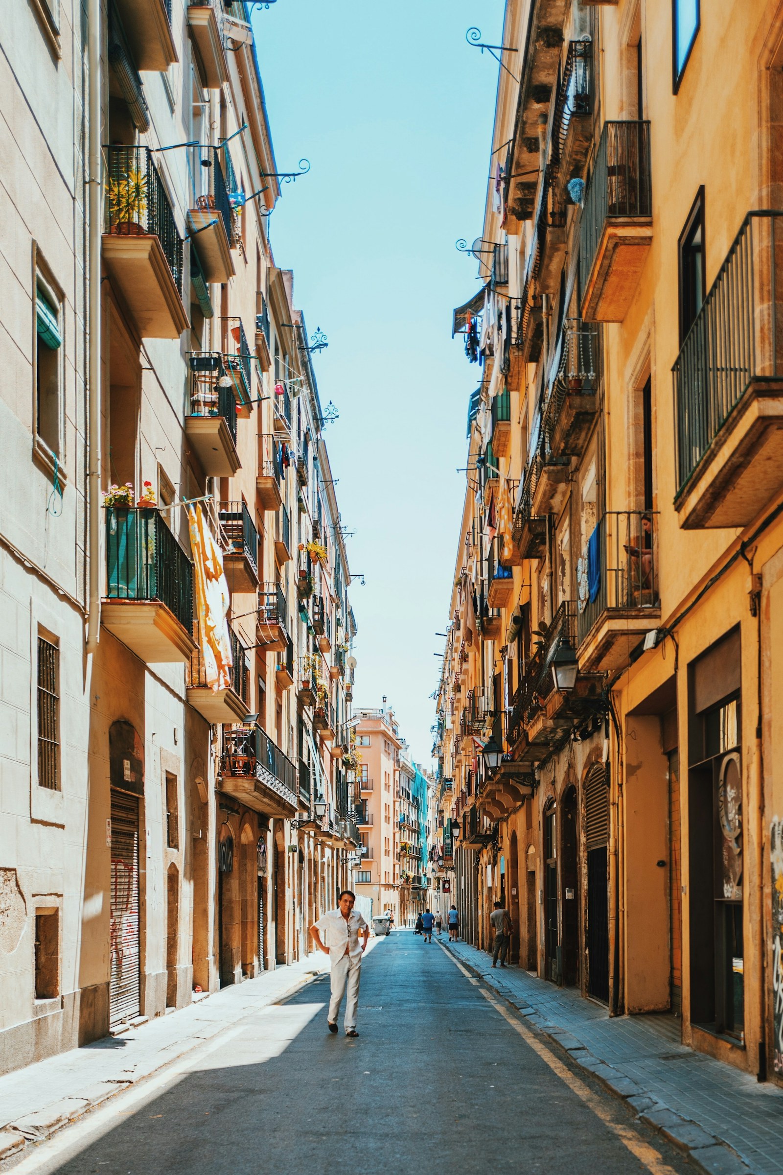 A person walking along a narrow street between Barcelona buildings