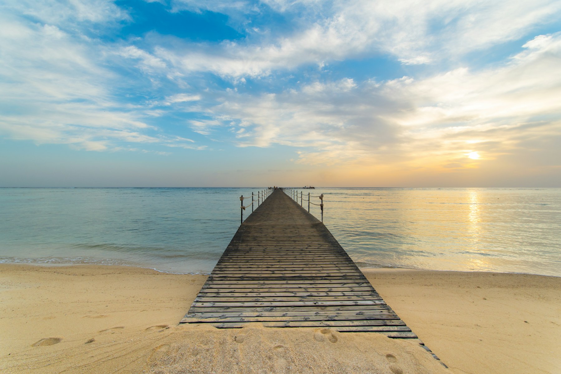 A wooden jetty at The Three Corners Sea Beach Resort
