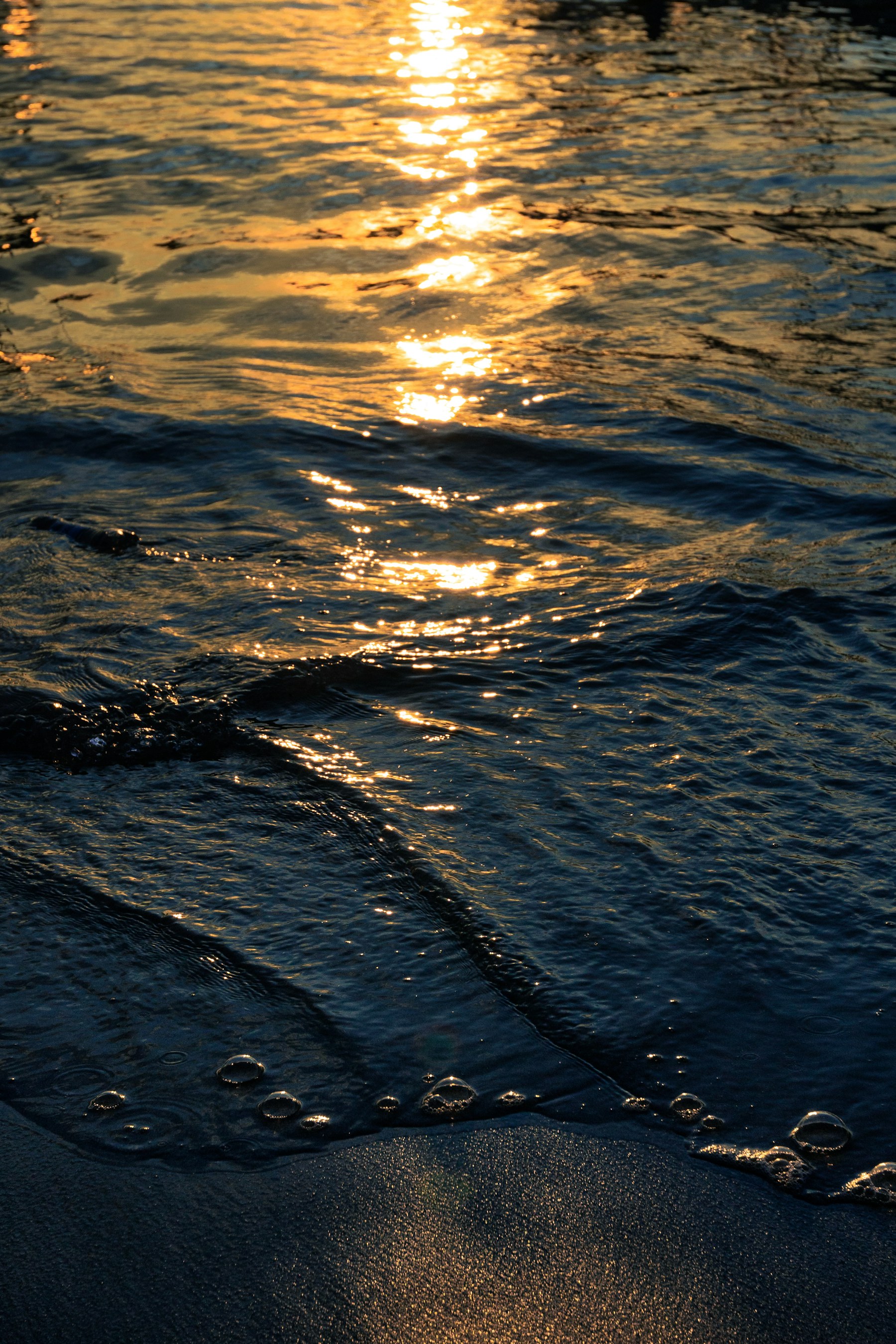 Warm sunlight reflected on waves at Pangandaran Beach
